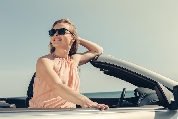 Mujer joven, conducir un coche, en la playa