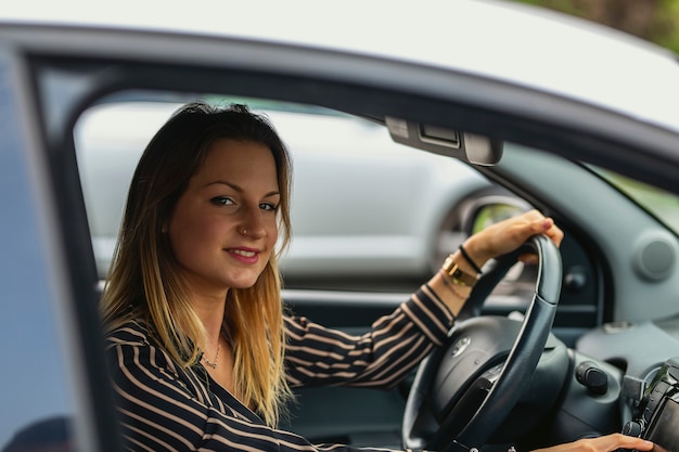 Foto mujer joven, conducir su coche