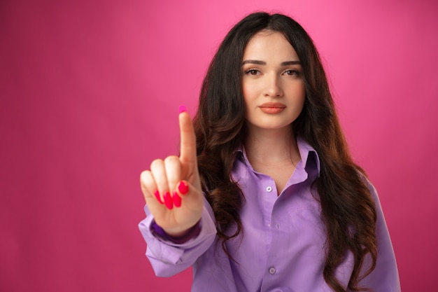 Mujer joven confiada que muestra el dedo acusador del gesto de la parada