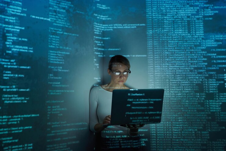 Foto mujer joven confiada usando la computadora contra un fondo oscuro