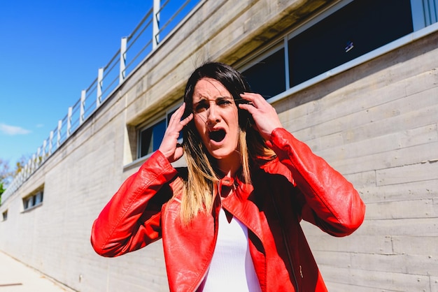 Mujer joven conmocionada de pie contra el edificio