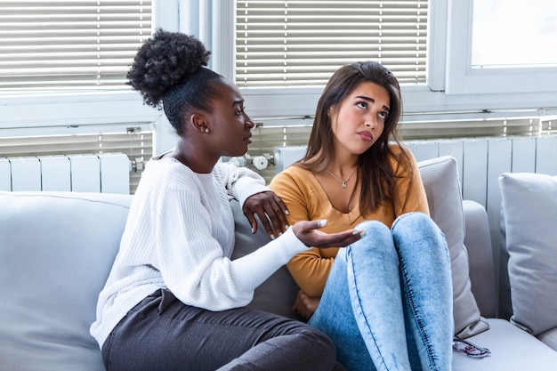 Mujer joven consolando a su amiga en casa