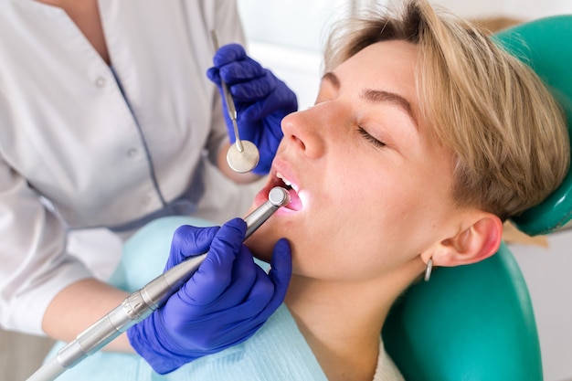 Mujer joven en la consulta del dentista. Revisión y tratamiento dental en una clínica dental. Higiene y tratamiento bucal.