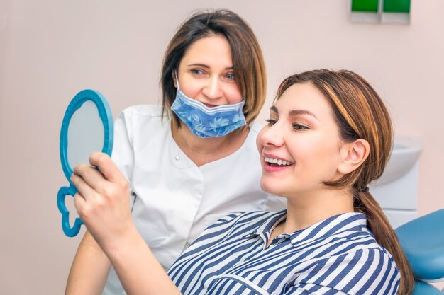 Mujer joven en el consultorio dental obteniendo un examen dental por dentista