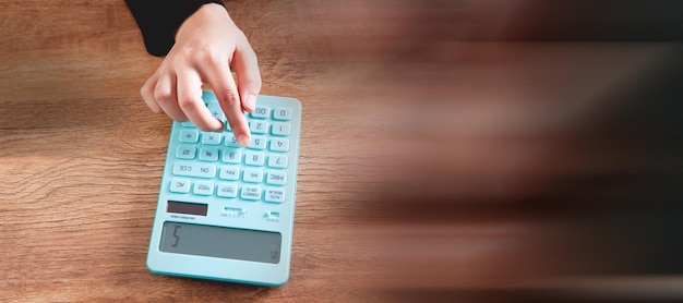 Mujer joven contando con una calculadora