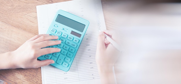 Mujer joven contando con una calculadora