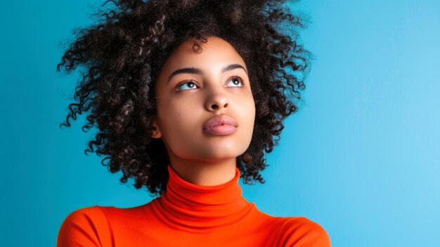 Mujer joven contemplando hacia arriba con un fondo azul vívido