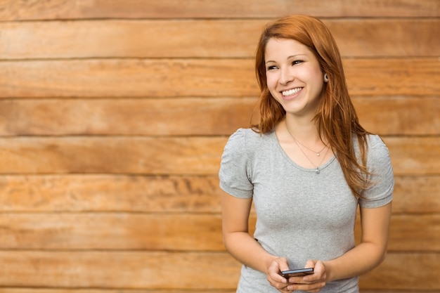 Mujer joven contenta que marca con su teléfono inteligente