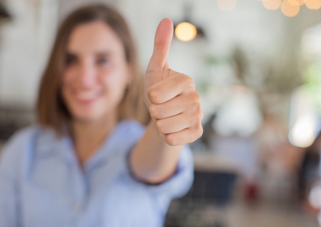 Foto mujer joven contra fondo de empresa signo de acuerdo