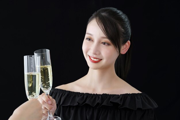 Mujer joven con copa de champaña y fondo negro