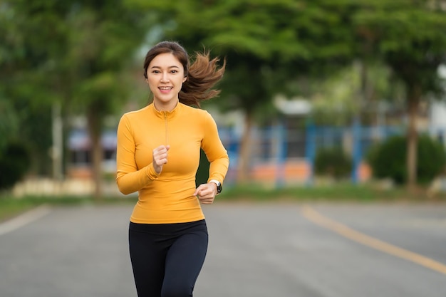 Mujer joven corriendo en el parque temprano en la mañana