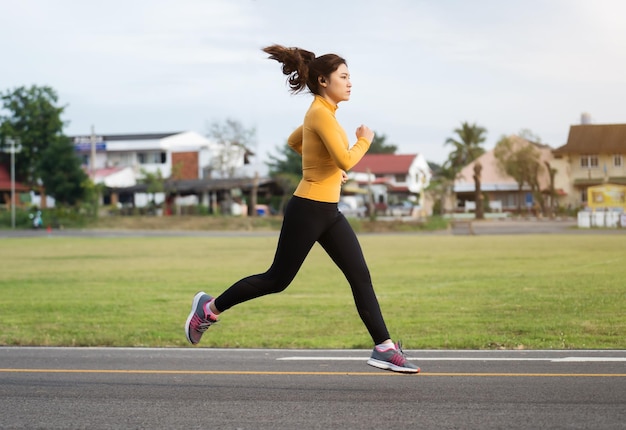 Mujer joven corriendo en el parque temprano en la mañana