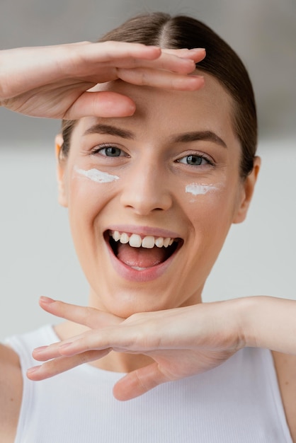 Foto mujer joven con una crema para el cuidado de la piel