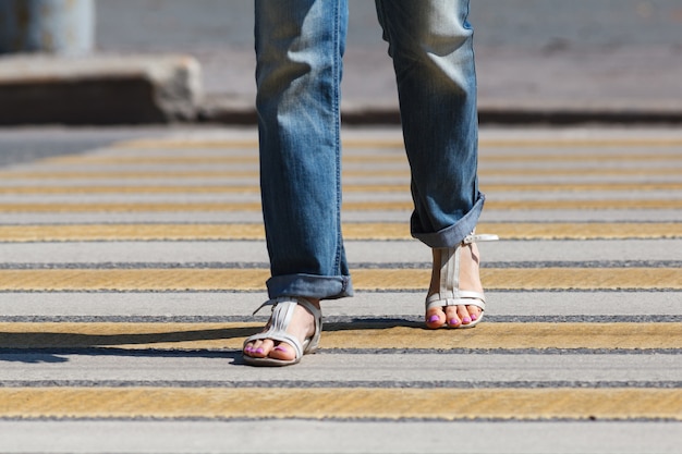 Mujer joven cruzar la calle en un cruce de peatones