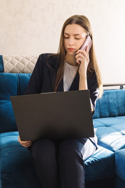 Mujer joven con un cuaderno está estudiando o trabajando en casa y llamando por teléfono