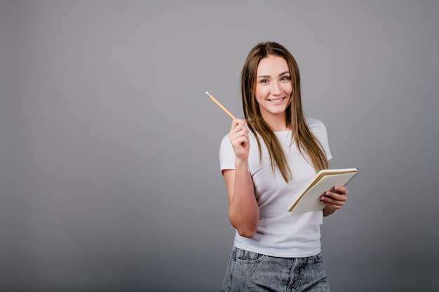 Mujer joven con cuaderno y lápiz