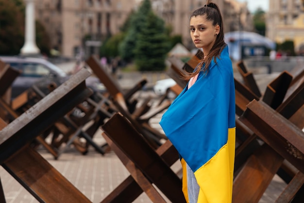 Mujer joven cubierta con la bandera ucraniana