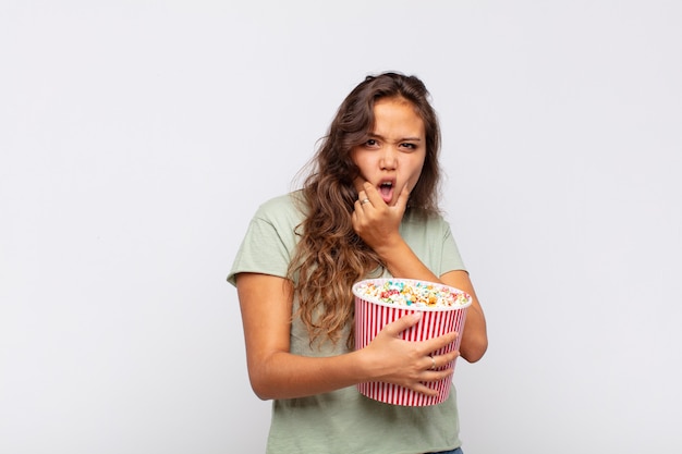 Mujer joven con un cubo de palomitas de maíz