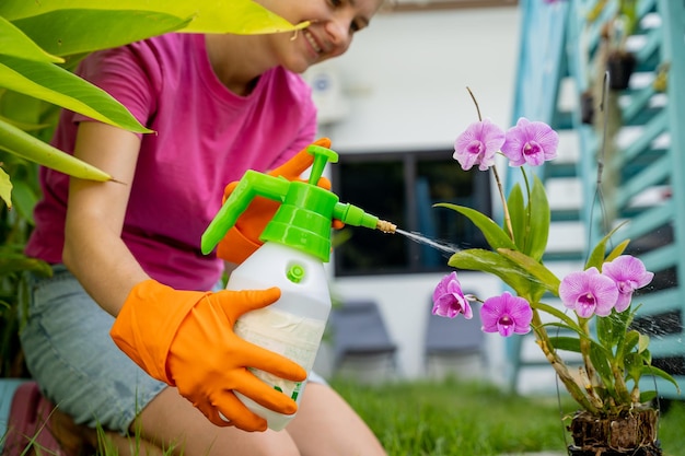 Una mujer joven cuida del jardín, rega, fertiliza y prune las plantas.