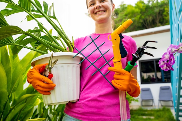 Una mujer joven cuida del jardín, rega, fertiliza y prune las plantas.