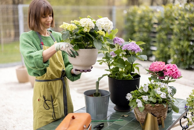 Mujer joven cuidando flores en el jardín