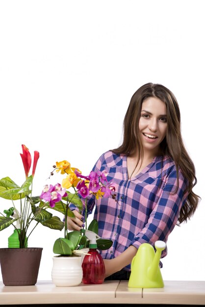 Mujer joven cuidando de las plantas caseras