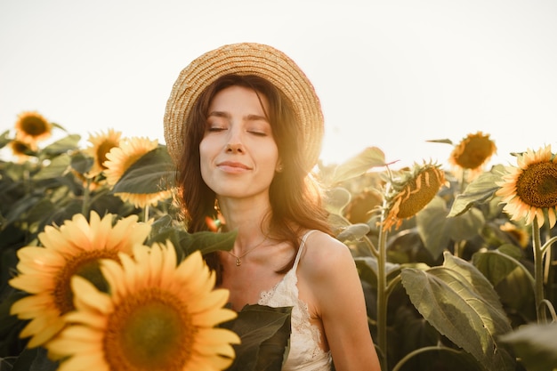 Mujer joven dando un paseo en el campo de girasoles en la mañana