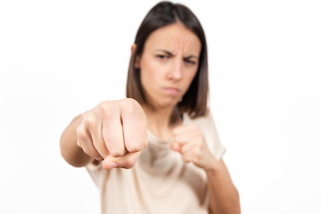 Una mujer joven dando un puñetazo o golpeando. Enfoque selectivo en el puño.