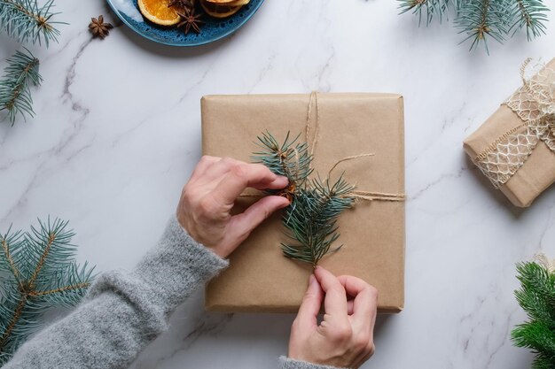 Mujer joven decora la caja de regalo de Navidad Vista aérea