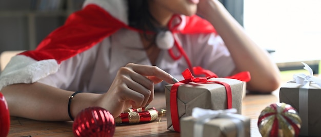 Mujer joven decorando regalos de Navidad en la sala de estar.