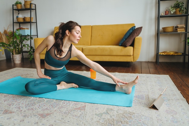 Mujer joven se dedica a fitness en casa