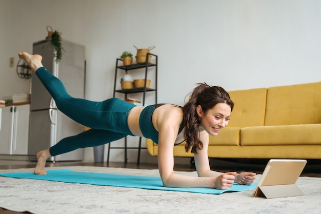 Mujer joven se dedica a fitness en casa