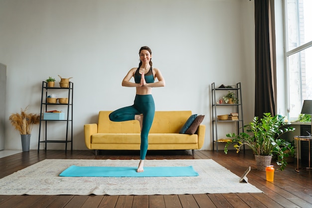 Mujer joven se dedica a fitness en casa