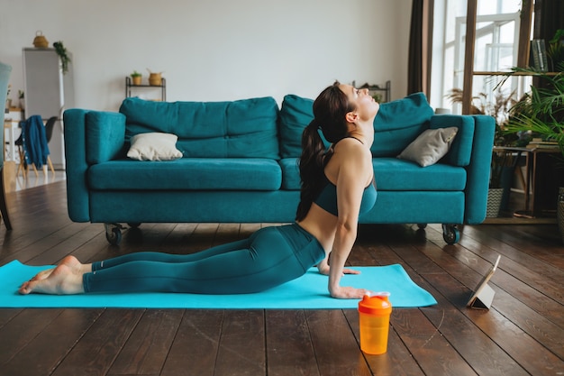 Mujer joven se dedica a fitness en casa