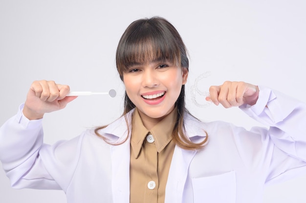 Mujer joven dentista sonriendo sobre fondo blanco studio