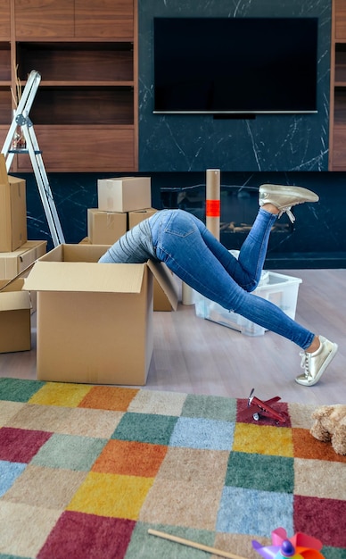 Foto mujer joven dentro de una caja mientras prepara la mudanza