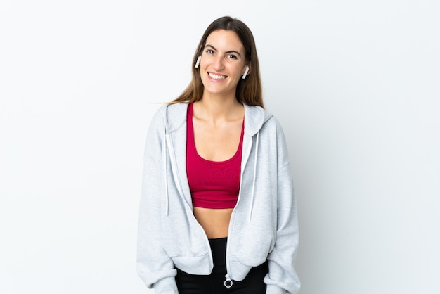 Mujer joven deporte sobre pared feliz y sonriente