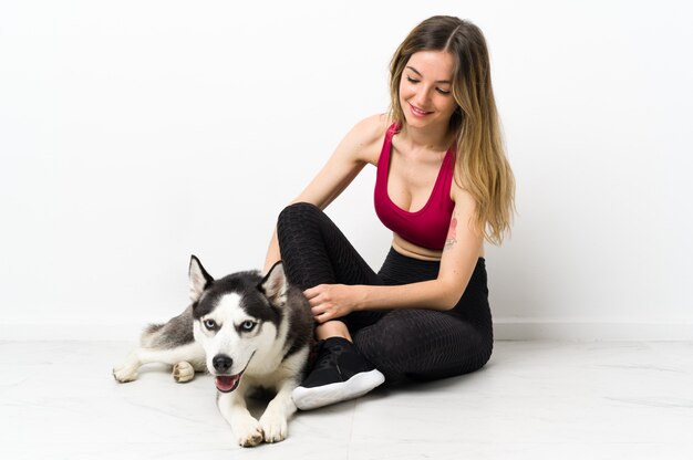 Mujer joven deporte con su perro sentado en el suelo