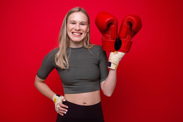 Mujer joven deportiva en guantes de boxeo rojos divirtiéndose Retrato emocional de un atleta