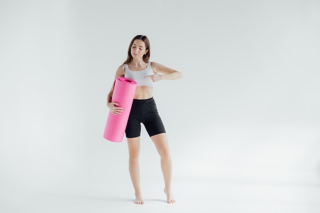 Mujer joven deportiva haciendo práctica de yoga aislada sobre fondo blanco. Concepto de vida saludable