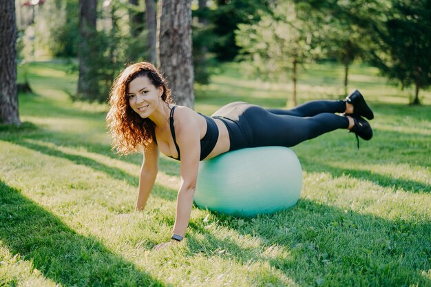 Mujer joven deportiva trabajando al aire libre con pelota