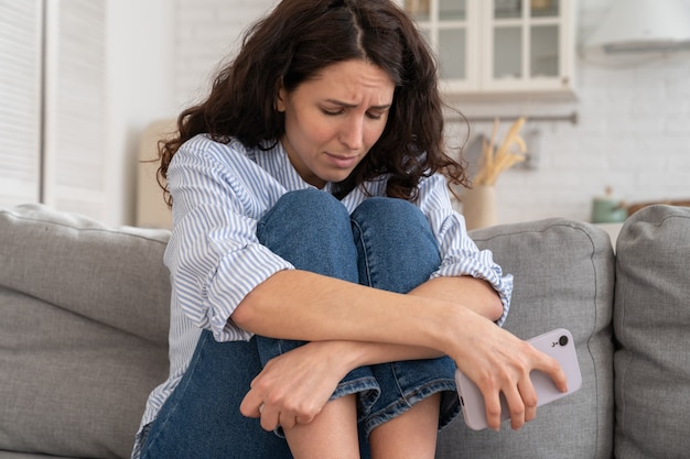 Mujer joven deprimida se siente triste después de escuchar malas noticias