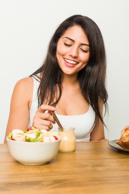 Mujer joven desayunando en la mesa