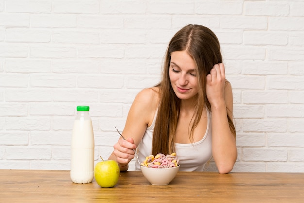 Mujer joven desayunando con tazón de cereales