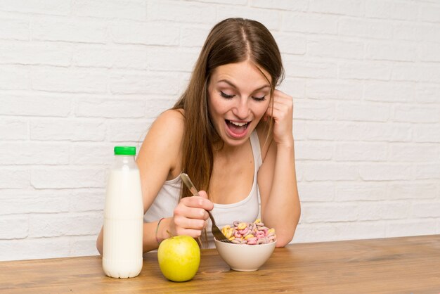 Mujer joven desayunando con tazón de cereales