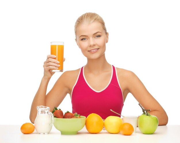 Mujer joven con desayuno saludable y celebración de jugo de naranja