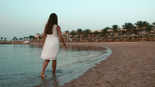 mujer joven, descalzo, dar pasos, en, playa, mujer joven, ambulante, en, playa