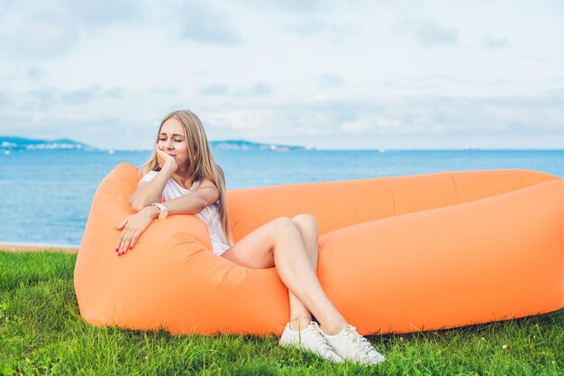 Mujer joven descansando en un sofá de aire en el parque .. lamzac