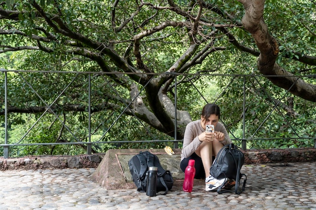 Foto mujer joven descendiendo en el barranco vegetación y árboles huentitan barranco guadalajara méxico