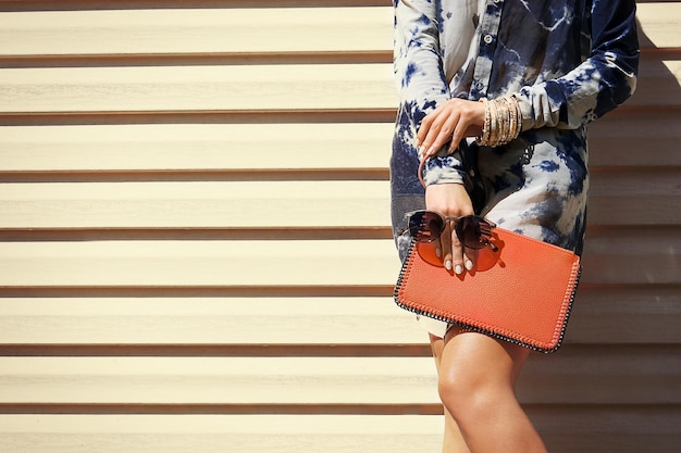 Mujer joven con detalles de moda sobre fondo de tablones